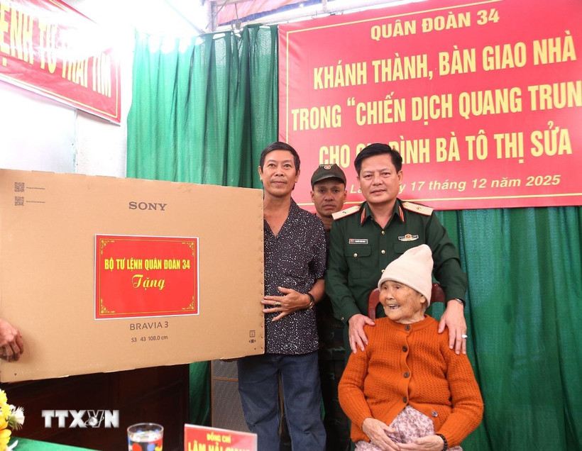 Thiếu tướng Nguyễn Trần Long, Ủy viên Ban Thường vụ Đảng uỷ, Phó Chính ủy Quân đoàn 34, trao tặng quà cho hộ gia đình bà Tô Thị Sửa. (Ảnh: Quang Thái/TTXVN)