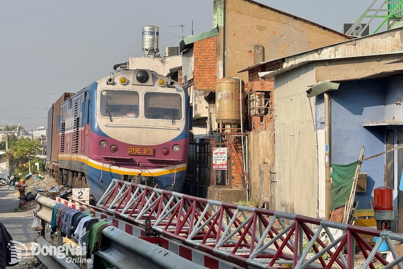 Tàu hỏa phải dừng lại không thể di chuyển qua vì vướng hiện trường vụ tai nạn giao thông. (Nguồn: Báo Đồng Nai)