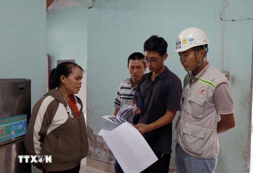 Người dân đối chiếu vết nứt được khảo sát trước thi công và hiện tại để có cơ sở giám định bồi thường thiệt hại. (Ảnh: Xuân Triệu/TTXVN)