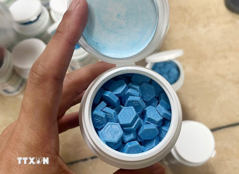 Đối tượng Nguyễn Tiến Đạt đã giấu số lượng ma túy là các viên nén màu xanh bên trong 26 hộp nhựa hình trụ tròn màu trắng bên ngoài dán nhãn có ghi chữ "altapharma." (Ảnh: TTXVN phát)