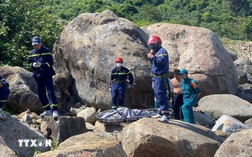 Lực lượng chức năng tiếp cận thi thể. (Ảnh: TTXVN phát)