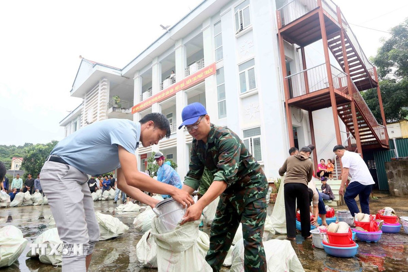 Lãnh đạo, cán bộ, công chức xã Huổi Một sắp xếp đồ dùng, vật dụng sinh hoạt hàng ngày để trao cho các hộ dân bị thiệt hại, ảnh hưởng do thiên tai, mưa lũ. (Ảnh: Quang Quyết/TTXVN)