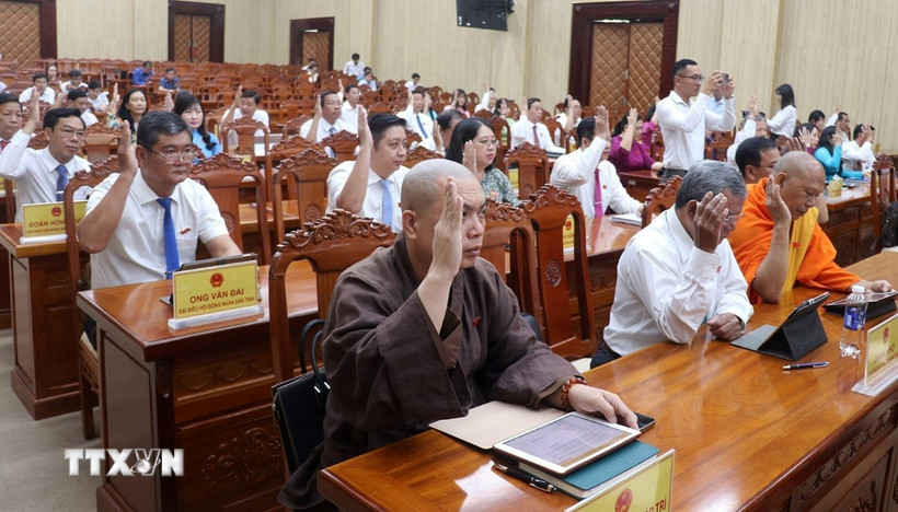 Đại biểu HĐND tỉnh Kiên Giang biểu quyết thông qua các nghị quyết. (Ảnh: Lê Huy Hải/TTXVN)