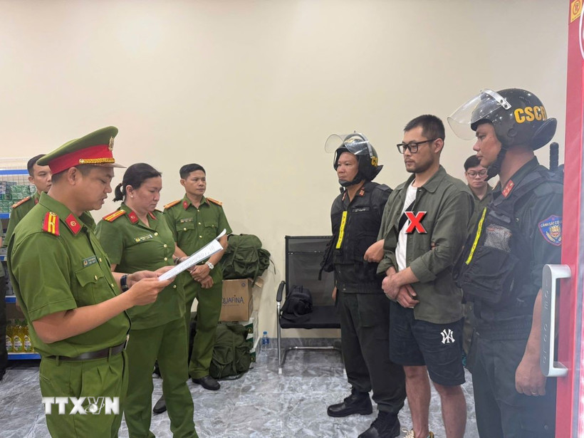 Công an đọc lệnh bắt đối tượng trong đường dây lừa đảo. (Ảnh: TTXVN phát)