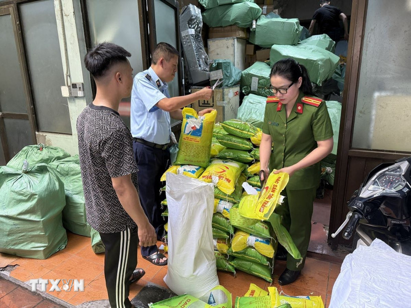 Lực lượng chức năng kiểm tra số gạo vi phạm. (Ảnh: TTXVN phát)