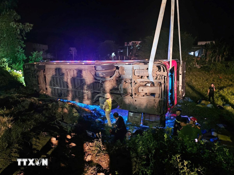 Lực lượng chức năng làm nhiệm vụ tại hiện trường tai nạn lật xe khách ở xã Phước Thành, huyện Tuy Phước (Bình Định). (Ảnh: TTXVN phát)