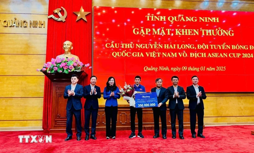 Bí thư Tỉnh ủy Vũ Đại Thắng và lãnh đạo tỉnh Quảng Ninh tặng hoa, tiền thưởng 350 triệu đồng cho cầu thủ Nguyễn Hai Long (từ nguồn ngân sách địa phương và xã hội hóa). (Ảnh: Thanh Tùng/TTXVN phát)