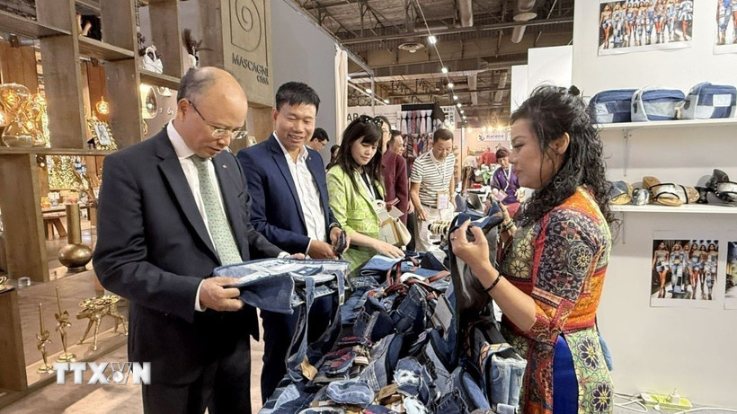 Đại sứ đặc mệnh toàn quyền Việt Nam tại Pháp Đinh Toàn Thắng tham quan gian hàng của doanh nghiệp Việt Nam. (Ảnh: Hữu Chiến/TTXVN)