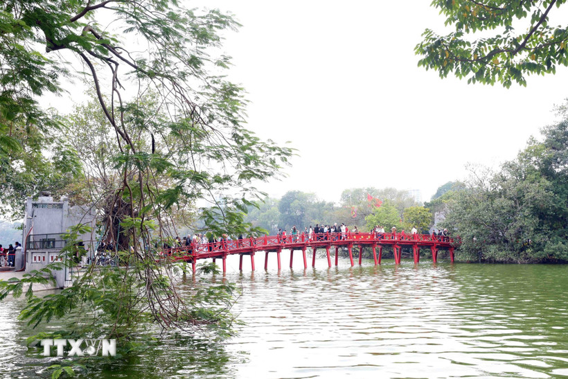 Du khách tham quan tại khu di tích cầu Thê Húc, đền Ngọc Sơn. (Ảnh: Phạm Kiên/TTXVN)
