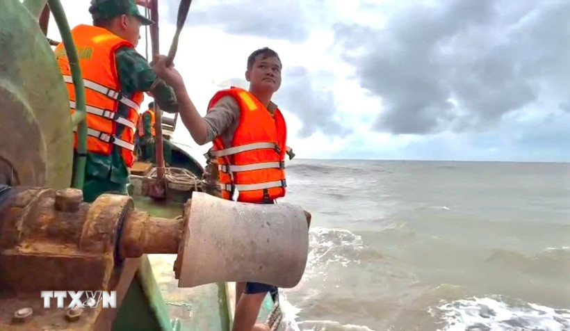 Thuyền viên Võ Văn Hiếu được cán bộ, chiến sỹ Đồn Biên phòng Sông Đốc đưa lên tàu an toàn. (Ảnh: TTXVN phát)