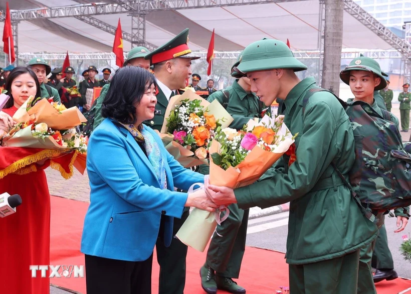 Bí thư Thành ủy Hà Nội Bùi Thị Minh Hoài tặng hoa, động viên và tiễn tân binh Quận Ba Đình lên đường nhập ngũ. (Ảnh: Văn Điệp/TTXVN)