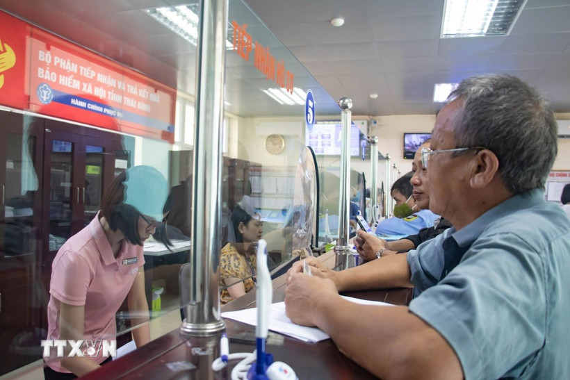 Cán bộ Bảo hiểm tỉnh Thái Bình tiếp người dân đến giải quyết thủ tục liên quan đến bảo hiểm. (Ảnh: Vũ Quang/TTXVN)