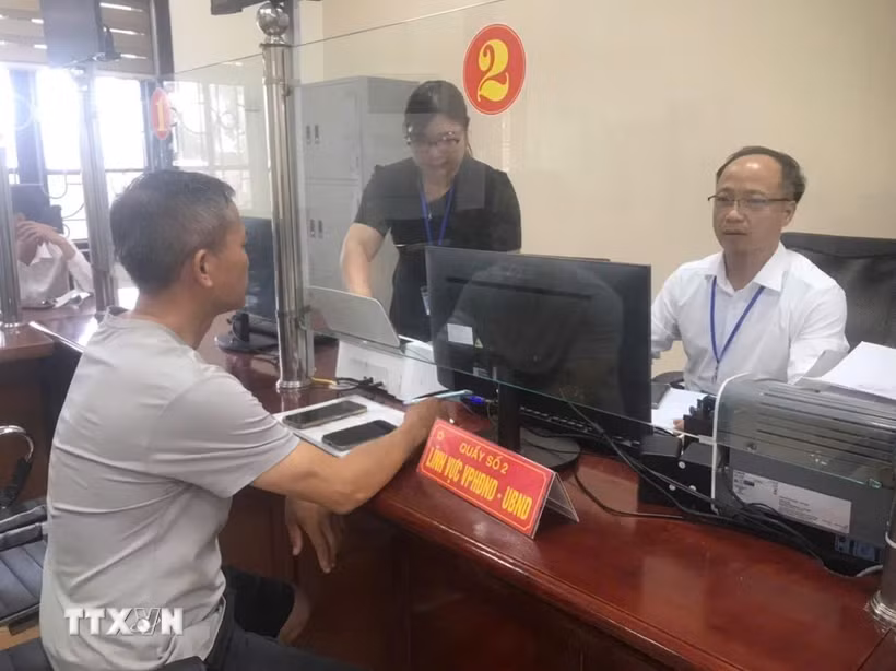 Cán bộ xã Cẩm Giàng - xã xa nhất vùng ven thành phố hướng dẫn người dân các thủ tục hành chính tại Trung tâm phục vụ hành chính công của xã. (Ảnh: Tiến Vĩnh/TTXVN)