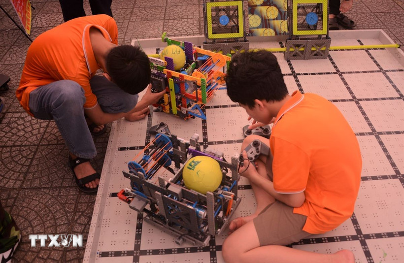 Học sinh khám phá các robot gắp bóng tại ngày hội STEM. (Ảnh: Văn Dũng/TTXVN)