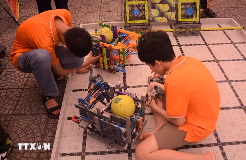 Học sinh khám phá các robot gắp bóng tại ngày hội STEM. (Ảnh: Văn Dũng/TTXVN)