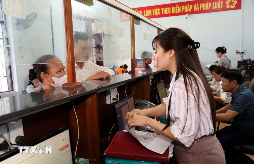 Cán bộ Trung tâm phục vụ hành chính công xã Hoàn Lão (tỉnh Quảng Trị) giải đáp các thắc mắc cho người dân trong giải quyết thủ tục hành chính. (Ảnh: Tá Chuyên/TTXVN)