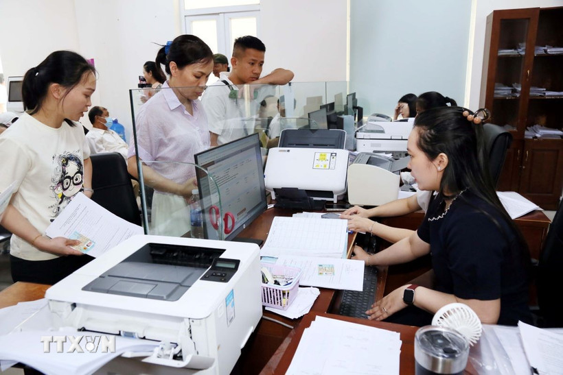 Cán bộ Trung tâm dịch vụ hành chính công phường Đồng Hới (Quảng Trị) giải quyết thủ tục hành chính cho người dân địa phương. (Ảnh: Tá Chuyên/TTXVN)