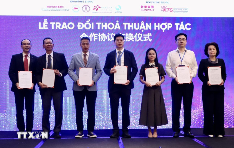Đại diện doanh nghiệp Việt Nam và Trung Quốc trao đổi thoả thuận hợp tác tại diễn đàn. (Ảnh: Xuân Anh/TTXVN)