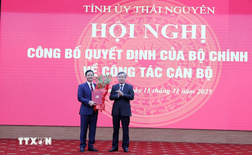 Ông Nguyễn Quang Dương, Phó trưởng Ban Tổ chức Trung ương trao quyết định cho ông Vương Quốc Tuấn. (Ảnh: Hoàng Nguyên/TTXVN)