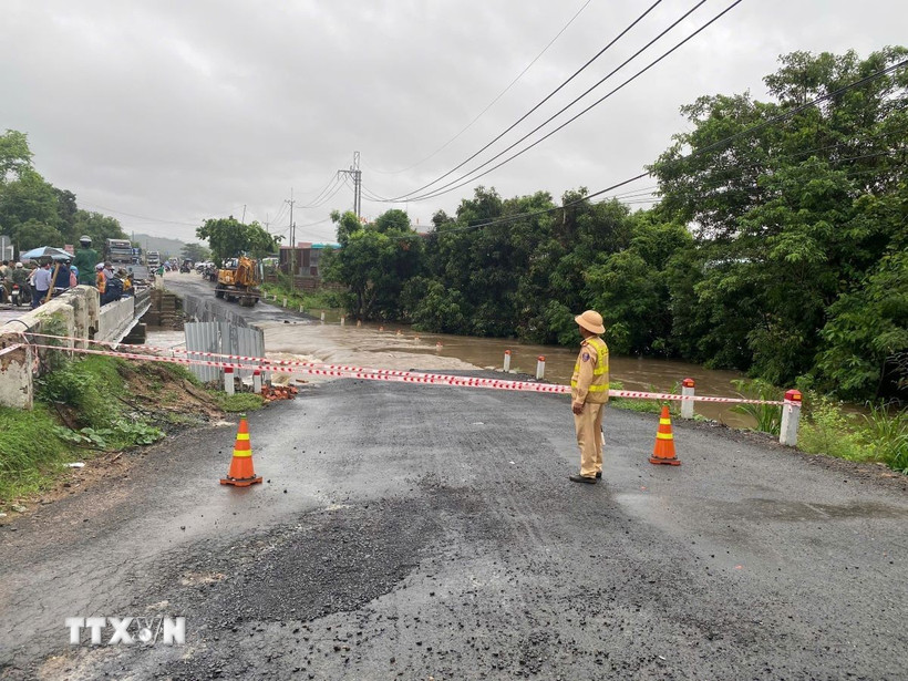 Lực lượng chức năng nỗ lực khắc phục hậu quả và đảm bảo an toàn cho người dân lưu thông qua điểm cầu Plei Lôk trên Quốc lộ 25. (Ảnh: TTXVN phát)