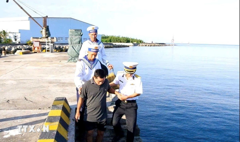 Cán bộ, chiến sỹ thị trấn Trường Sa đưa ông Trần Công Nhanh trở lại tàu để rời đảo. (Ảnh: TTXVN phát)
