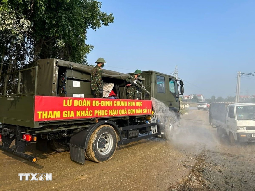 Xe phun khử khuẩn của Lữ đoàn 86 - Binh chủng Hóa học tiến hành phun khử khuẩn, xử lý ô nhiễm môi trường tại các khu vực bị ngập úng trên địa bàn xã Trung Giã. (Ảnh: Quốc Lũy/TTXVN)