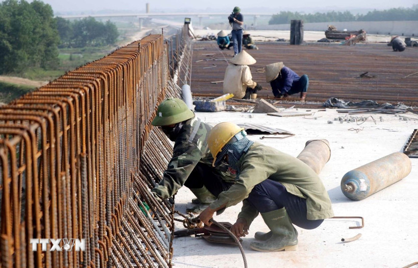 Công nhân Tổng công ty 319 Bộ Quốc phòng thi công trên cây cầu bắc qua sông Già, huyện Can Lộc (Hà Tĩnh). (Ảnh: Công Tường/TTXVN)