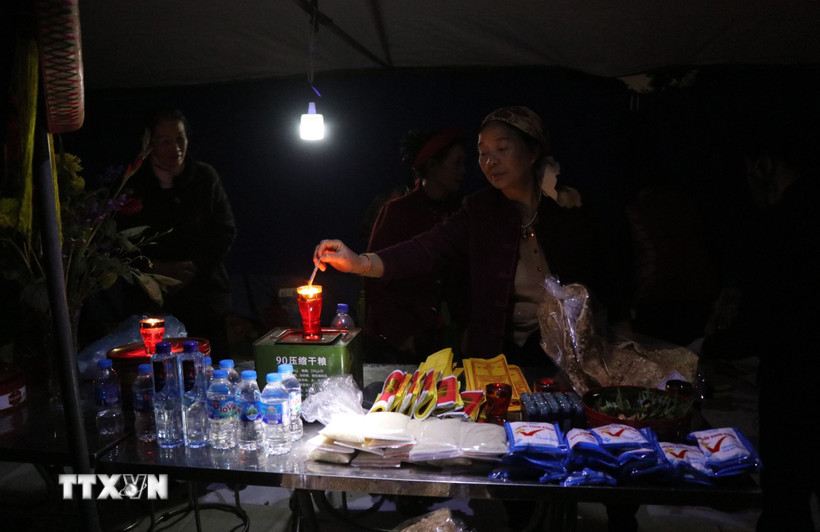 Người bán hàng tại chợ Âm dương thường bán tiền, vàng, gạo muối, lửa với ý nghĩa mua may bán rủi. (Ảnh: Thanh Thương/TTXVN)