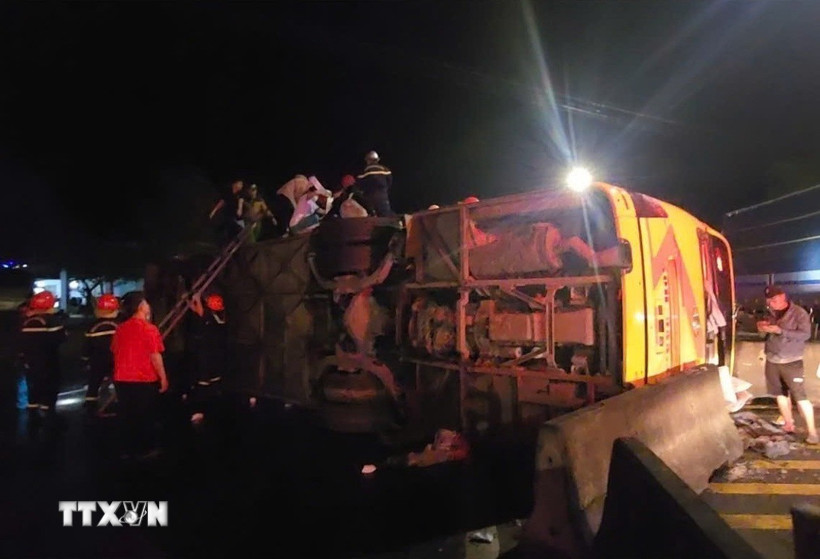 Chiếc xe khách bị lật nghiêng. (Ảnh: TTXVN phát)