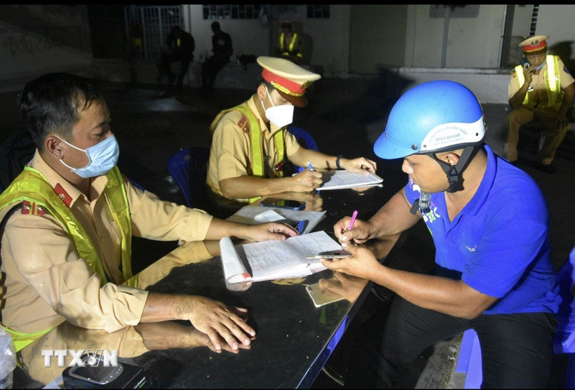 Lực lượng cảnh sát giao thông tỉnh Kiên Giang lập biên bản vi phạm hành chính người tham gia giao thông. (Ảnh: Lê Sen/TTXVN)