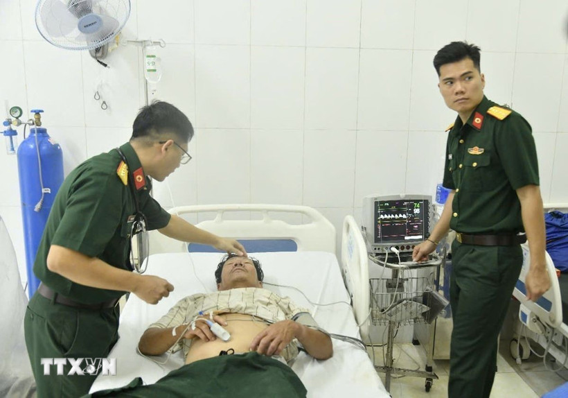 Các bác sỹ quân y tại Bệnh xá đảo Nam Yết thăm khám cho bệnh nhân Đoàn Tính. (Ảnh: TTXVN phát)