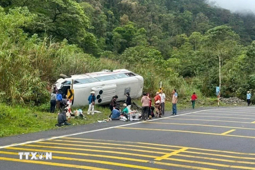 Xe khách chở 25 hành khách, đang lưu thông theo hướng từ Đà Lạt đi Nha Trang thì bất ngờ bị lật nghiêng bên lề đường. (Ảnh: TTXVN phát)