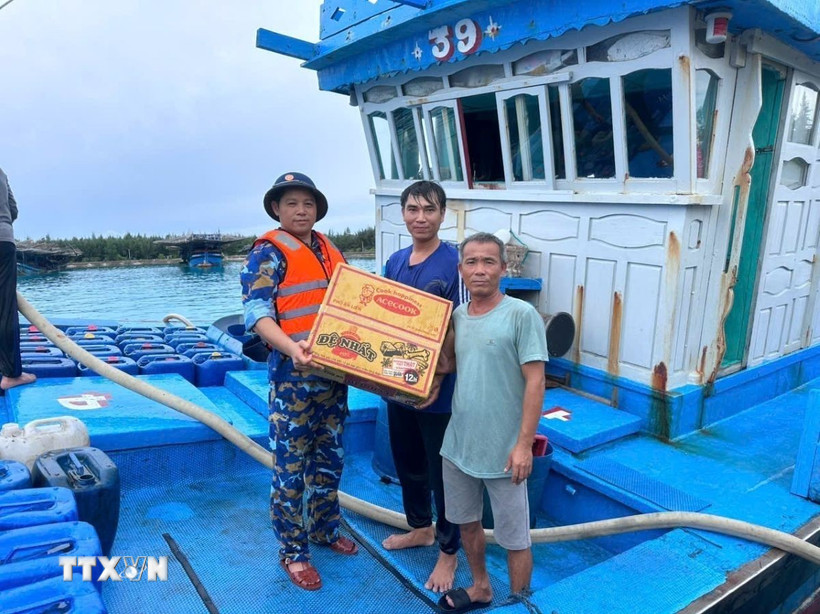 Hỗ trợ mỳ tôm, rau xanh, nước ngọt cho ngư dân vào tránh, trú bão. (Ảnh: TTXVN phát)