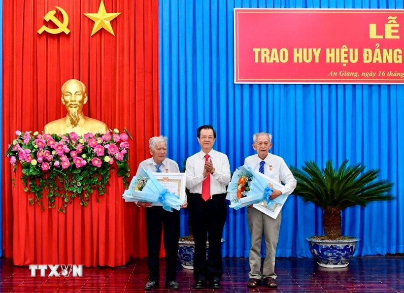 Ông Lê Hồng Quang, Bí thư Tỉnh ủy An Giang trao huy hiệu 65 năm tuổi Đảng cho 2 đảng viên. (Ảnh: Thanh Sang/TTXVN)