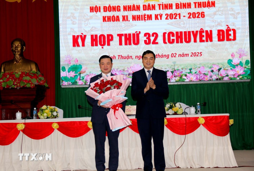 Ông Nguyễn Hoài Anh, Bí thư Tỉnh ủy, Chủ tịch HĐND tỉnh, tặng hoa chúc mừng ông Đỗ Hữu Huy được bầu giữ chức Chủ tịch UBND tỉnh Bình Thuận. (Ảnh: Nguyễn Thanh/TTXVN)