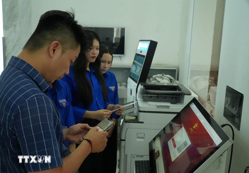 Hỗ trợ người dân khi làm thủ tục trực tuyến. (Ảnh: Hữu Duyên/TTXVN)