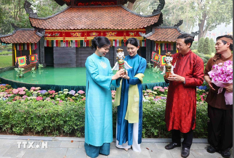 Bà Ngô Phương Ly, Phu nhân Tổng Bí thư Tô Lâm tặng con rối nước cho bà Loo Tze Lui, Phu nhân Thủ tướng Singapore Lawrence Wong. (Ảnh: Phạm Kiên/TTXVN)