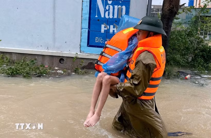 Chiến sỹ Phòng Cảnh sát phòng cháy, chữa cháy và cứu nạn, cứu hộ (Công an tỉnh Thanh Hóa) nỗ lực tiếp cận hộ dân ở thôn Bái, xã Trường Lâm (Thanh Hóa). (Ảnh: TTXVN phát)