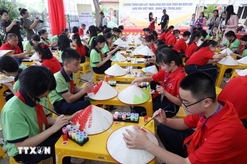 Thiếu nhi Lạng Sơn (Việt Nam) và thiếu nhi Bằng Tường (Trung Quốc) tham gia trải nghiệm vẽ nón lá Việt Nam tại Bảo tàng tỉnh Lạng Sơn. (Ảnh: Anh Tuấn/TTXVN)