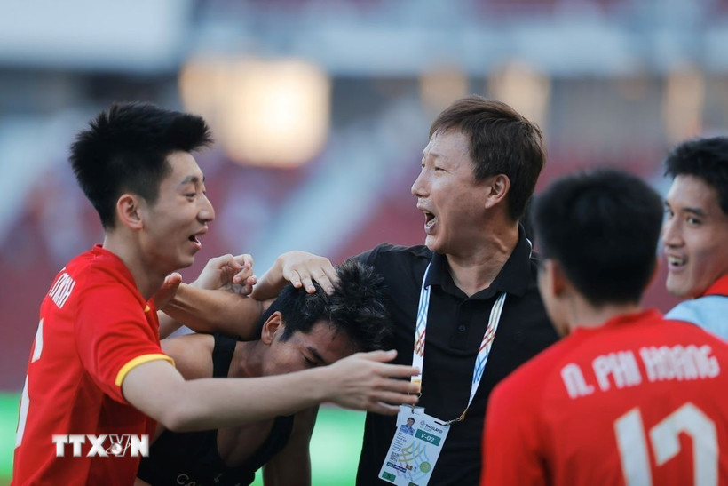 Thầy trò HLV Kim Sang Sik vỡ òa cảm xúc khi giành vé vào chung kết SEA Games 33. (Ảnh: Minh Quyết/TTXVN)