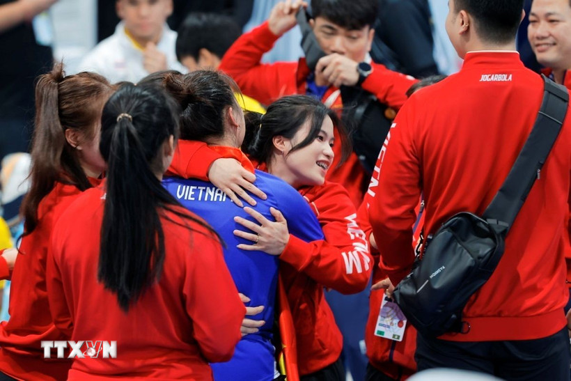 Niềm vui của đội tuyển cử tạ Việt Nam khi Trần Đình Thắng giành HCV. (Ảnh: Minh Quyết/TTXVN)
