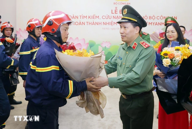Trung tướng Lê Văn Tuyến, Thứ trưởng Bộ Công an tặng hoa chúc mừng cán bộ, chiến sỹ đoàn tìm kiếm, cứu nạn và cứu hộ Bộ Công an hoàn thành nhiệm vụ trở về từ Myanmar. (Ảnh: Phạm Kiên/TTXVN)