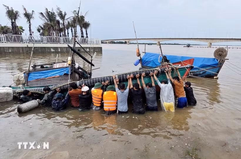 Lực lượng Bộ đội Biên phòng Quảng Trị phối hợp với lực lượng liên quan tiến hành trục vớt tàu, thuyền của ngư dân bị ảnh hưởng sau bão. (Ảnh: TTXVN phát)