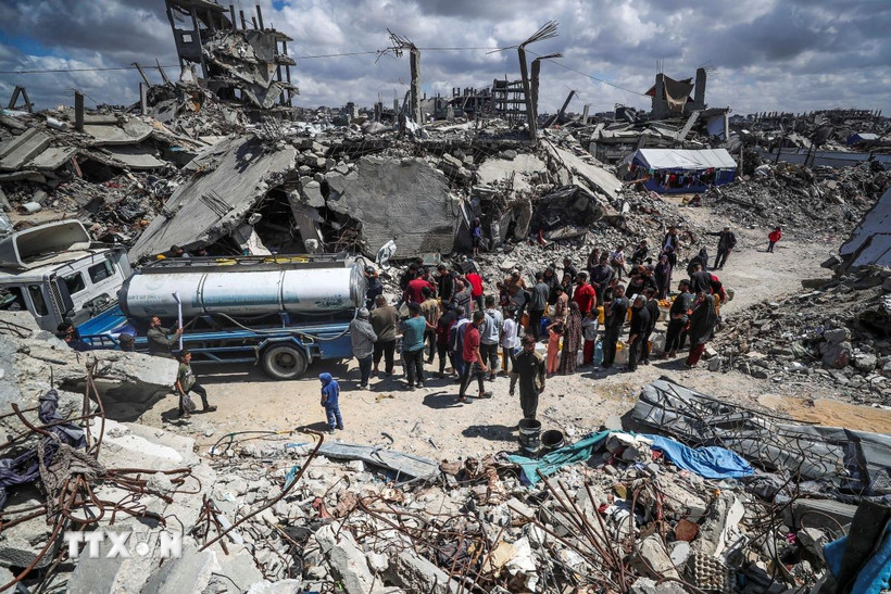 Người dân Palestine xếp hàng chờ lấy nước sinh hoạt tại trại tị nạn ở Dải Gaza ngày 10/4/2025. (Ảnh: THX/TTXVN)
