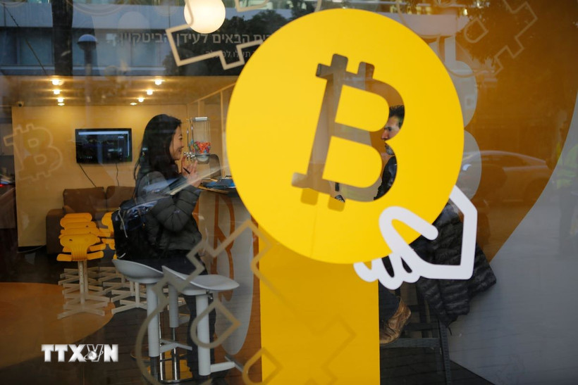 Biểu tượng đồng Bitcoin tại một quầy giao dịch ở Tel Aviv, Israel. (Ảnh: THX/TTXVN)