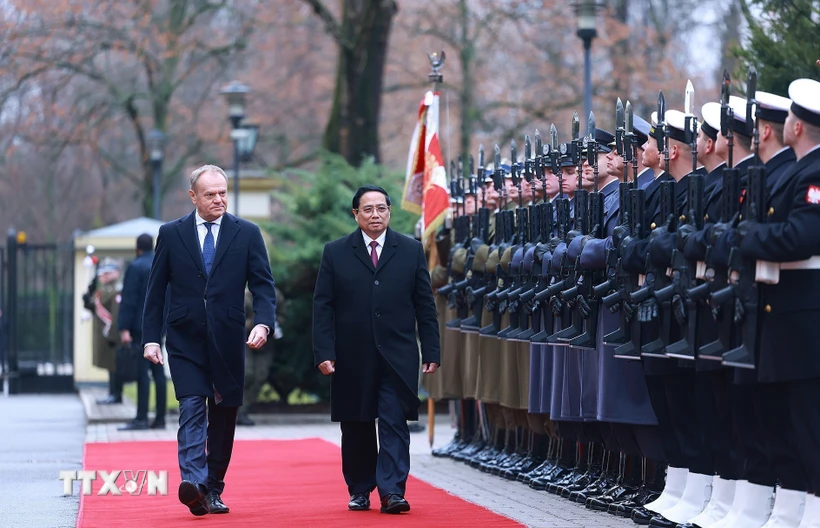 Thủ tướng Phạm Minh Chính và Thủ tướng Cộng hòa Ba Lan Donald Tusk duyệt đội danh dự. (Ảnh: Dương Giang/TTXVN)