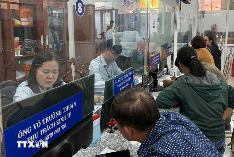 Cán bộ công chức giải thích, tư vấn, hướng dẫn để người dân nắm rõ các thủ tục hành chính. (Ảnh: Hữu Duyên/TTXVN)