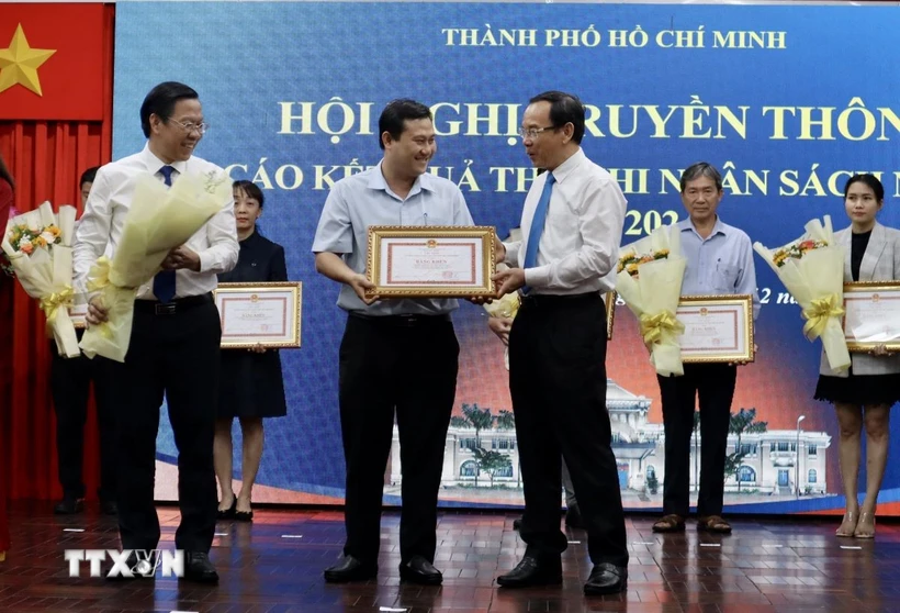 Bí thư Thành ủy Thành phố Hồ Chí Minh Nguyễn Văn Nên và Chủ tịch UBND Thành phố Phan Văn Mãi trao tặng bằng khen cho các doanh nghiệp nộp ngân sách trên 1.000 tỷ đồng trong năm 2024. (Ảnh: Xuân Anh/TTXVN)