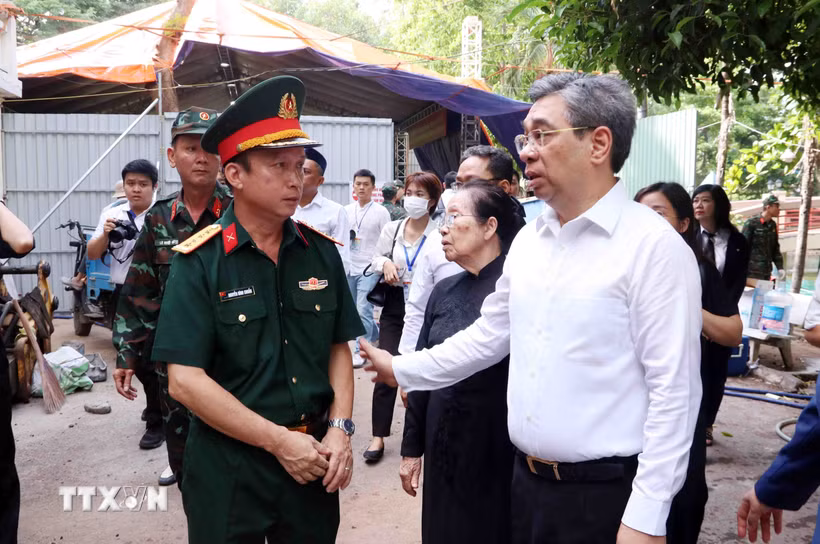 Ông Nguyễn Phước Lộc (phải), Phó Bí thư Thành ủy, Chủ tịch Ủy ban Mặt trận Tổ quốc Việt Nam Thành phố Hồ Chí Minh, động viên các lực lượng làm nhiệm vụ tìm kiếm, quy tập hài cốt liệt sỹ tại công viên Lê Thị Riêng. (Ảnh: Xuân Khu/TTXVN)
