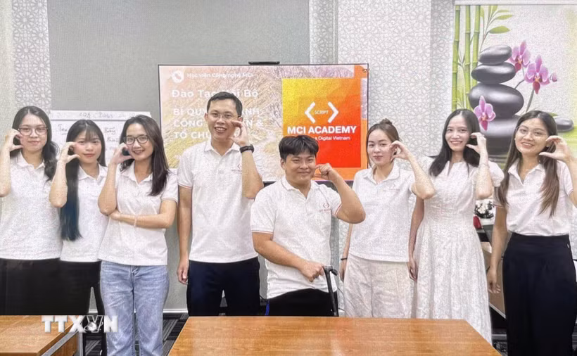 Anh Lê Tấn Đạt (thứ 4, từ trái sang) tham gia đào tạo công nghệ thông tin trực tiếp cho ứng viên. (Ảnh: TTXVN phát)
